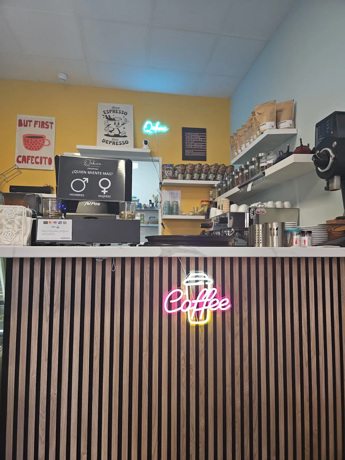 Barra de Qahwa con letrero neon Coffee y pared amarilla