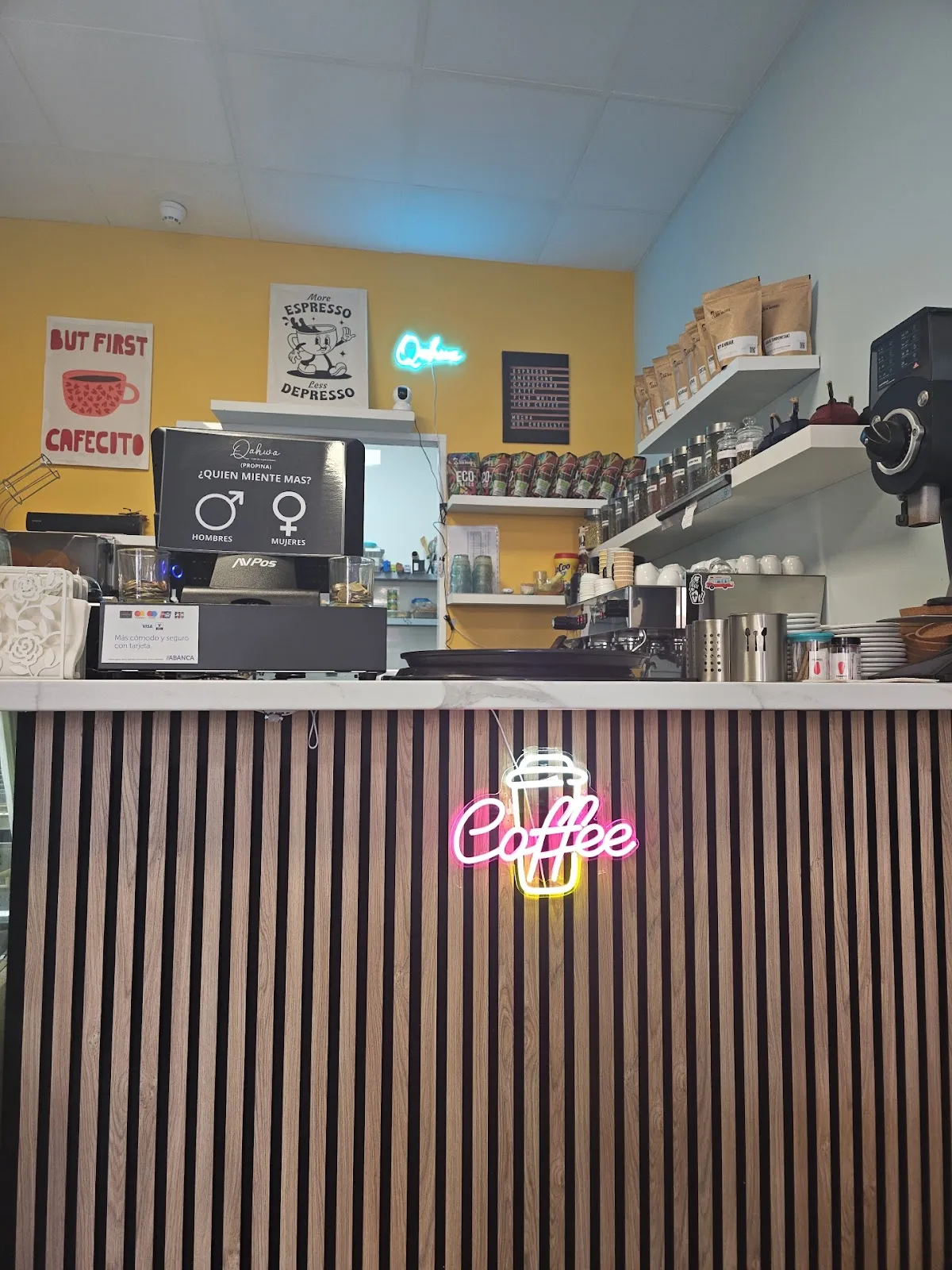 Barra de Qahwa con letrero neon Coffee y pared amarilla